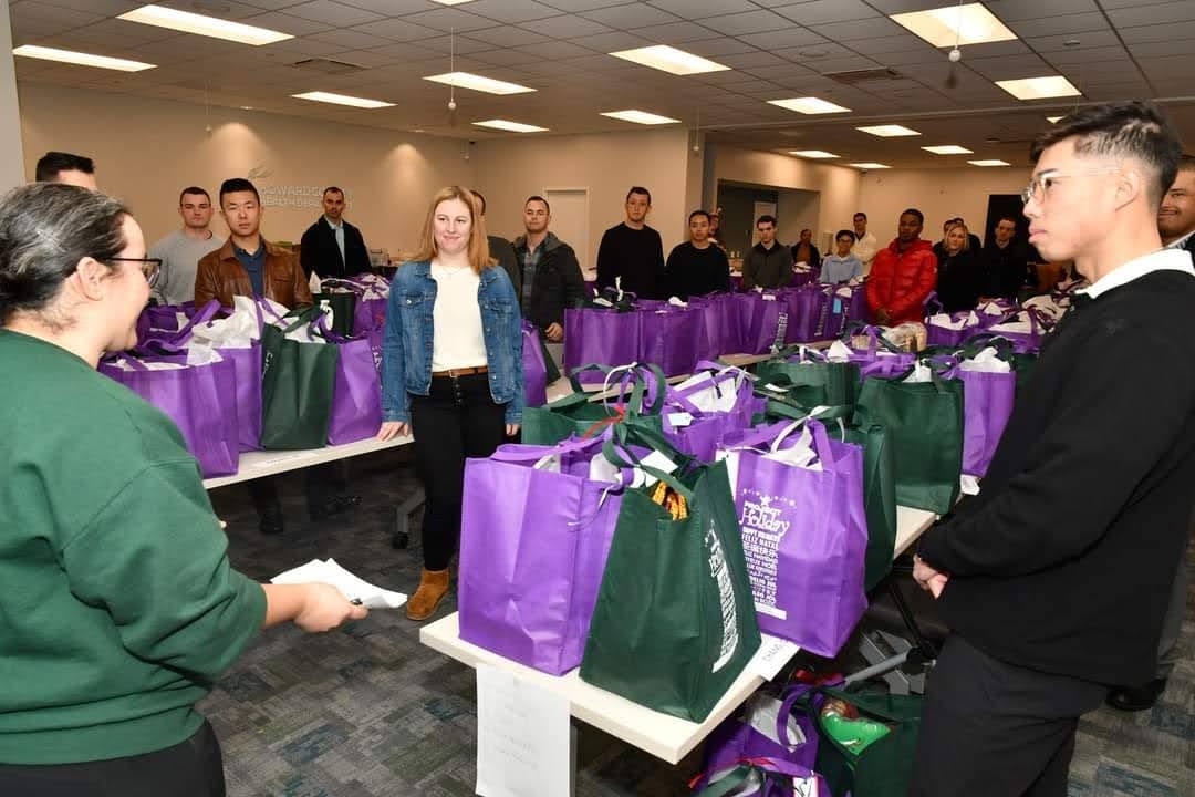 Project Holiday Coordinator, Morgan, giving instructions to a room full of gift deliverers from Police Academy 48.